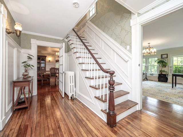 304 Main St, Ridgefield, CT 06877 - staircase with a decorative wall, radiator, hardwood / wood-style floors, a chandelier, and crown molding