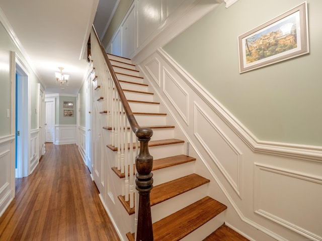 304 Main St, Ridgefield, CT 06877 - stairs with a decorative wall, wood-type flooring, crown molding, a chandelier, and wainscoting