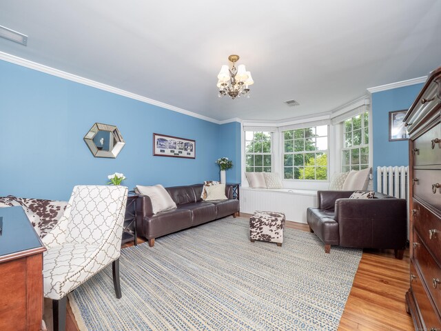304 Main St, Ridgefield, CT 06877 - living area with crown molding, a chandelier, radiator heating unit, and light wood-style flooring