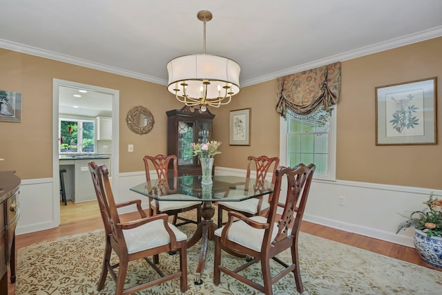 11 Ledgewood Rd, Redding, CT 06896 - dining space featuring light wood-style flooring, crown molding, a chandelier, and a wainscoted wall