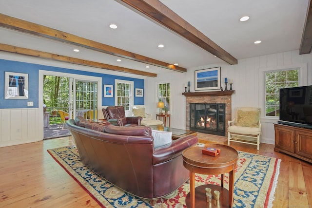 11 Ledgewood Rd, Redding, CT 06896 - living area with a decorative wall, light wood-style flooring, beamed ceiling, a brick fireplace, and healthy amount of natural light