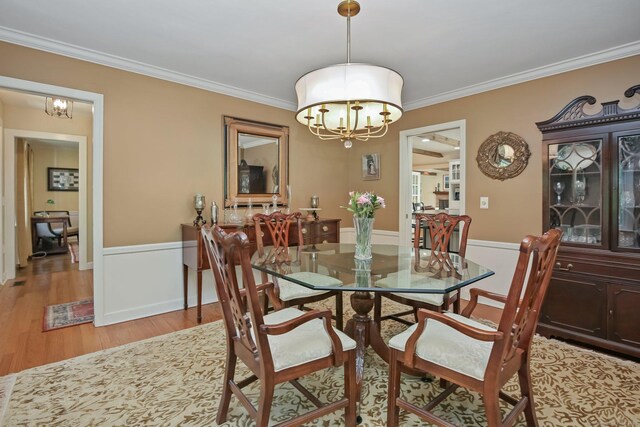 11 Ledgewood Rd, Redding, CT 06896 - dining room featuring a chandelier, crown molding, light wood finished floors, and a wainscoted wall
