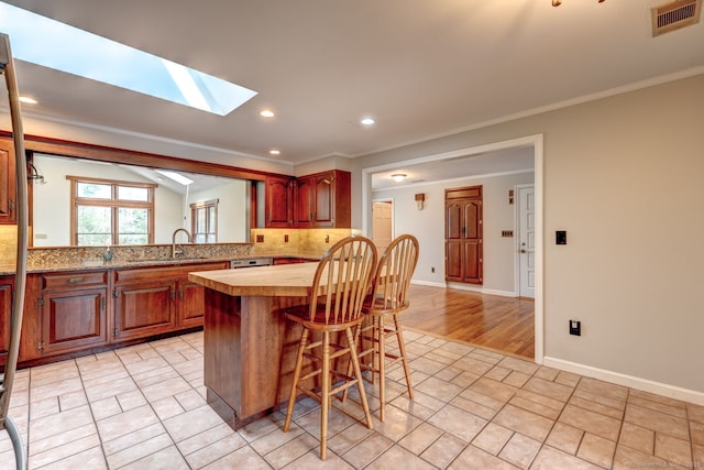3 Clear View Dr, Mansfield, CT 06250 - kitchen featuring tasteful backsplash, light countertops, a breakfast bar area, a skylight, and ornamental molding