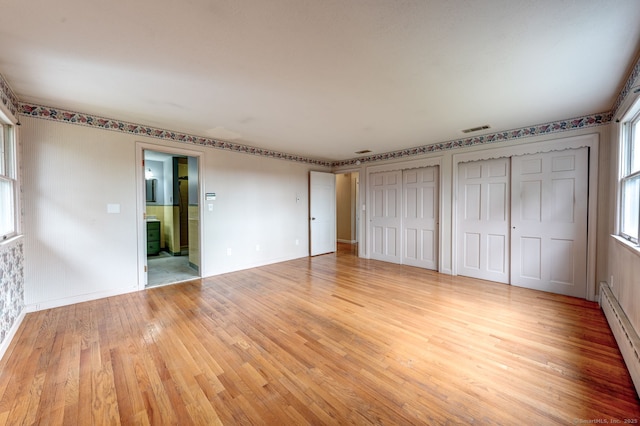 3 Clear View Dr, Mansfield, CT 06250 - unfurnished bedroom featuring a baseboard heating unit, light wood-type flooring, multiple closets, and baseboards