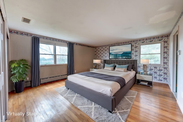 3 Clear View Dr, Mansfield, CT 06250 - bedroom featuring wallpapered walls, a baseboard heating unit, light wood finished floors, and an accent wall