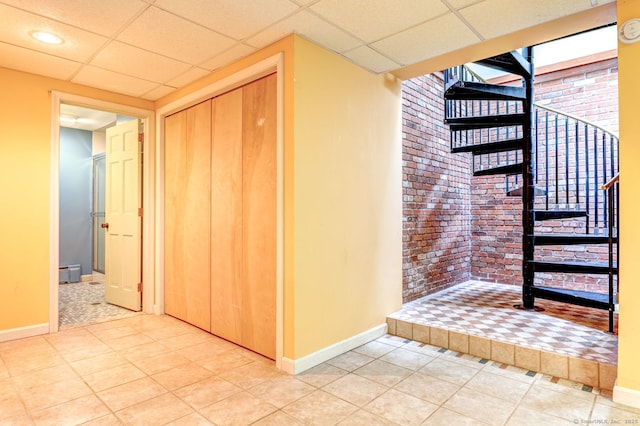 3 Clear View Dr, Mansfield, CT 06250 - hall with baseboards, brick wall, light tile patterned floors, a paneled ceiling, and stairway