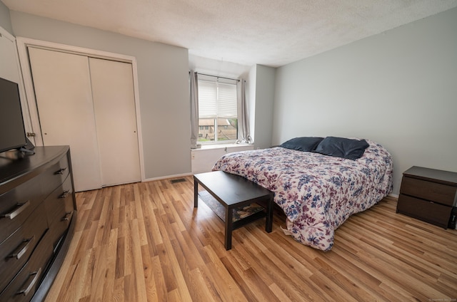 183 Thompson St Unit B, East Haven, CT 06513 - bedroom with light wood finished floors, a closet, baseboards, and a textured ceiling