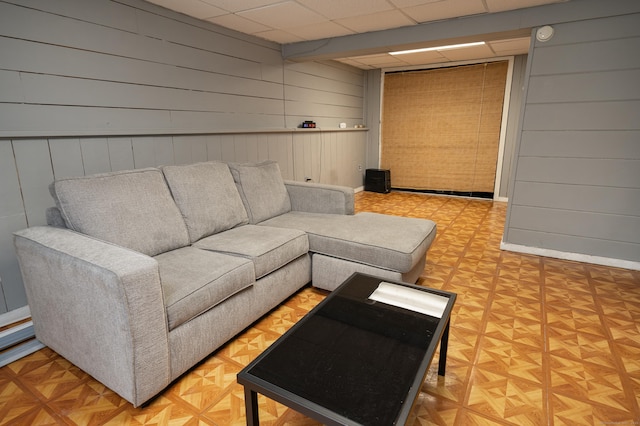 183 Thompson St Unit B, East Haven, CT 06513 - living area with wood walls, a drop ceiling, and baseboards