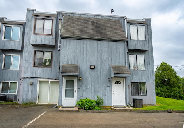 183 Thompson St Unit B, East Haven, CT 06513 - view of property featuring roof with shingles, uncovered parking, and central air condition unit