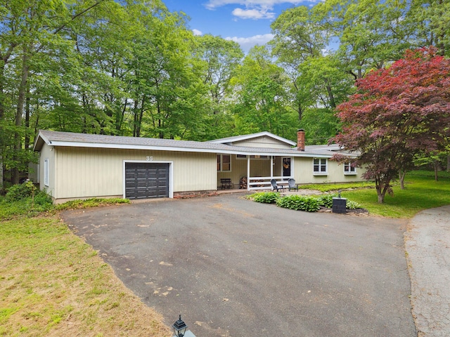 35 Old Acres Rd, East Haddam, CT 06469 - view of front of property with an attached garage, asphalt driveway, a porch, a front lawn, and a chimney