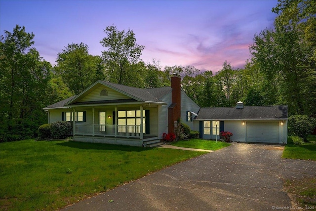 166 Mine Rd, Bristol, CT 06010 - view of front of home with a porch, asphalt driveway, an attached garage, and a lawn