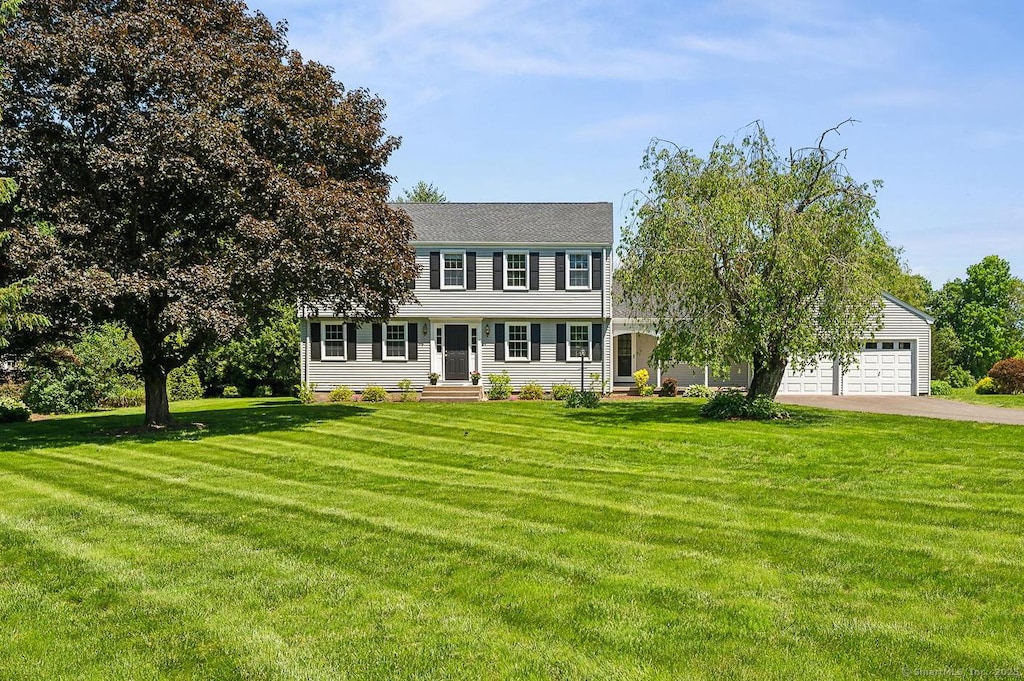 14 Case Cir, Simsbury, CT 06092 - view of front of home featuring driveway, a front yard, and an attached garage