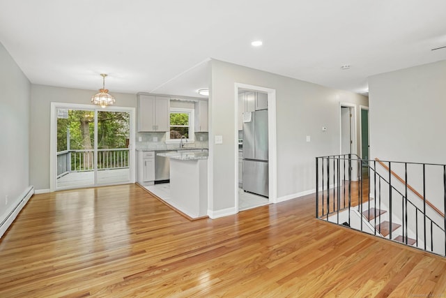 9 Marlin Dr, Norwalk, CT 06854 - kitchen with stainless steel appliances, light wood finished floors, baseboards, backsplash, and recessed lighting