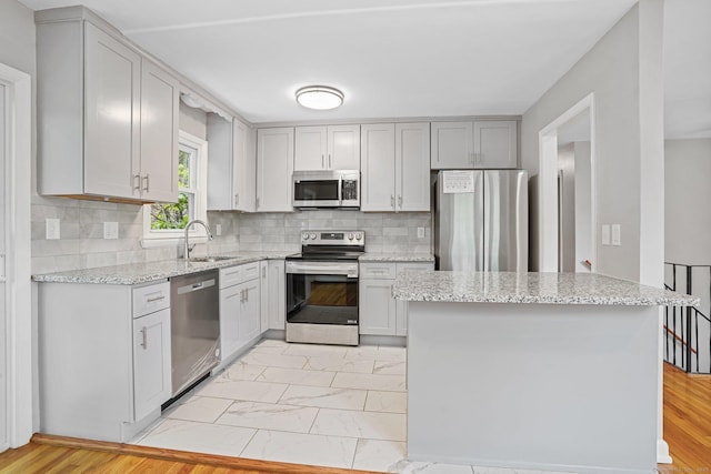 9 Marlin Dr, Norwalk, CT 06854 - kitchen with stainless steel appliances, a sink, light stone counters, tasteful backsplash, and light marble finish flooring