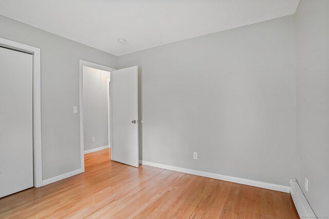 9 Marlin Dr, Norwalk, CT 06854 - unfurnished bedroom featuring wood finished floors, baseboards, baseboard heating, and a closet