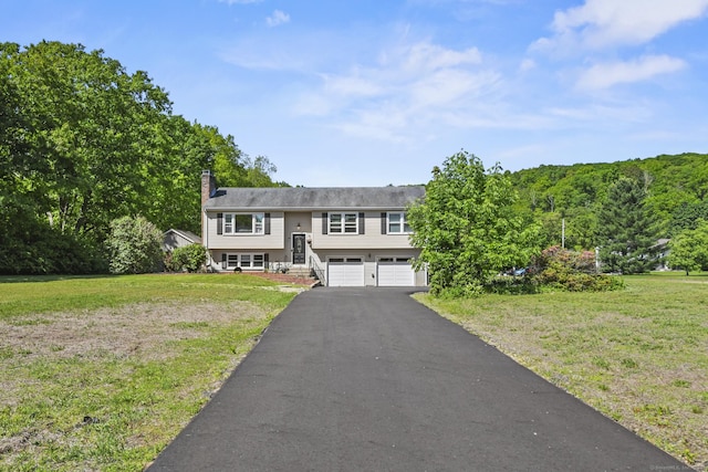 96 Flanders River Rd, Coventry, CT 06238 - split foyer home with driveway, an attached garage, a front yard, and a chimney