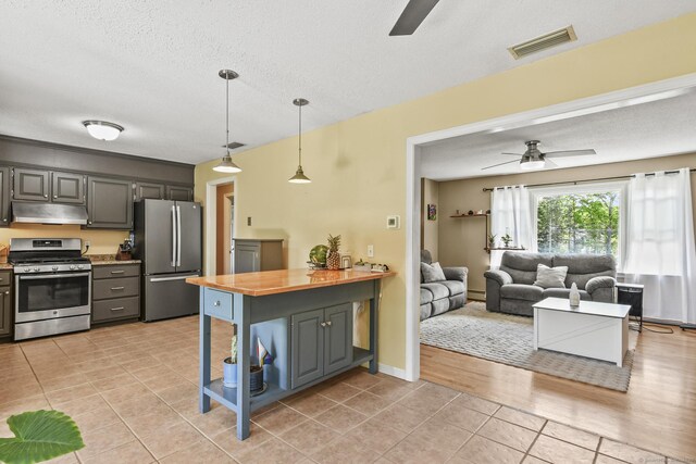 96 Flanders River Rd, Coventry, CT 06238 - kitchen with stainless steel appliances, a ceiling fan, under cabinet range hood, light tile patterned floors, and wooden counters