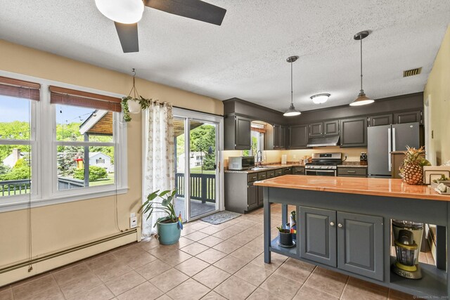 96 Flanders River Rd, Coventry, CT 06238 - kitchen with appliances with stainless steel finishes, butcher block counters, under cabinet range hood, a baseboard heating unit, and a textured ceiling