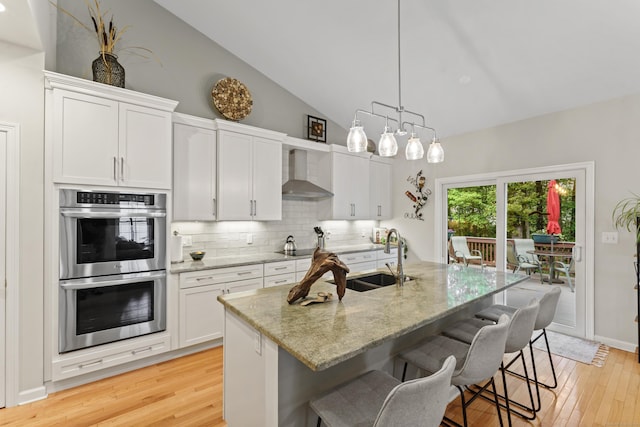 403 Mulligan Dr Unit 403, Oxford, CT 06478 - kitchen with wall chimney exhaust hood, stainless steel double oven, a sink, high vaulted ceiling, and light wood-type flooring