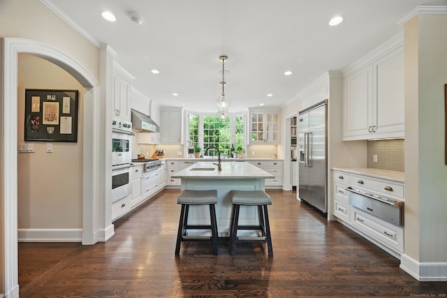 276 Greenley Rd, New Canaan, CT 06840 - kitchen featuring stainless steel appliances, a warming drawer, wall chimney range hood, an island with sink, and backsplash