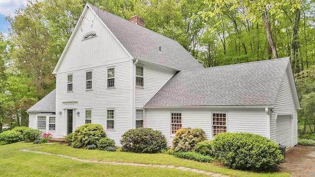 6 Cedar Cir, Newtown, CT 06470 - view of front facade featuring roof with shingles, a chimney, a front yard, and a garage