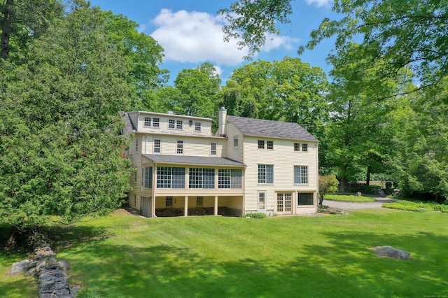 708 Ponus Rdg, New Canaan, CT 06840 - back of house featuring a yard, a sunroom, a chimney, and a shingled roof