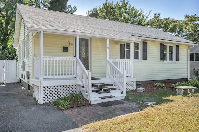 29 Risley St, East Hartford, CT 06118 - view of front of home featuring a chimney, roof with shingles, and covered porch