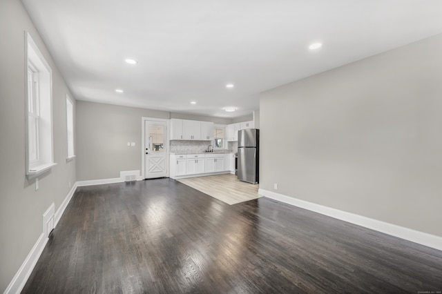 29 Risley St, East Hartford, CT 06118 - unfurnished living room featuring light wood finished floors, baseboards, recessed lighting, and a sink