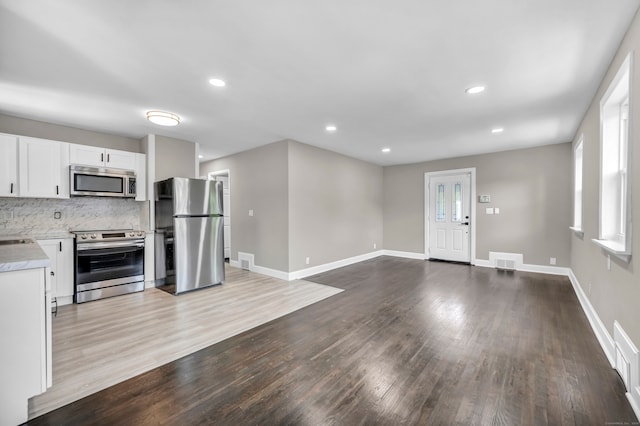 29 Risley St, East Hartford, CT 06118 - kitchen featuring stainless steel appliances, light countertops, dark wood-style floors, white cabinets, and baseboards