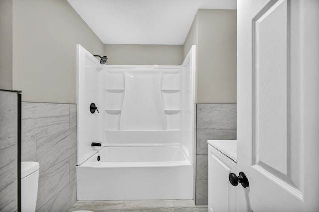 29 Risley St, East Hartford, CT 06118 - full bath featuring tile walls, shower / bath combination, toilet, marble finish floors, and wainscoting