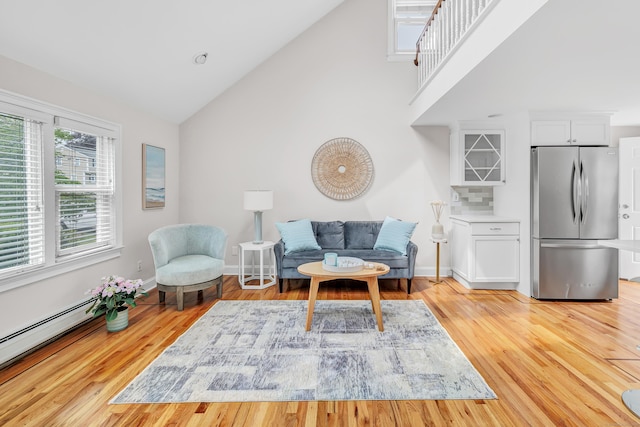 5 Wildmere Ln, Norwalk, CT 06851 - living area with high vaulted ceiling, a baseboard radiator, light wood-type flooring, and baseboards