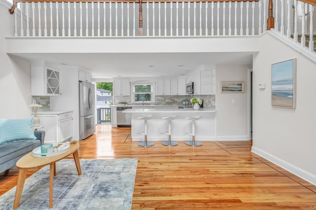 5 Wildmere Ln, Norwalk, CT 06851 - living room featuring light wood-style floors, baseboards, and a high ceiling