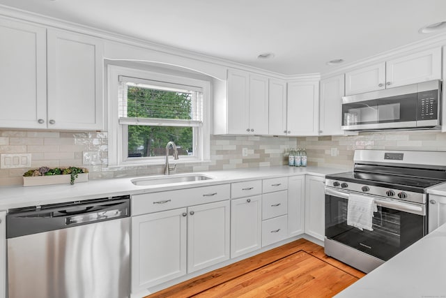 5 Wildmere Ln, Norwalk, CT 06851 - kitchen with appliances with stainless steel finishes, a sink, white cabinetry, and light countertops