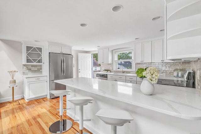 5 Wildmere Ln, Norwalk, CT 06851 - kitchen with stainless steel appliances, a peninsula, a sink, decorative backsplash, and white cabinetry