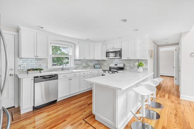 5 Wildmere Ln, Norwalk, CT 06851 - kitchen featuring stainless steel appliances, a sink, light wood-type flooring, and white cabinets