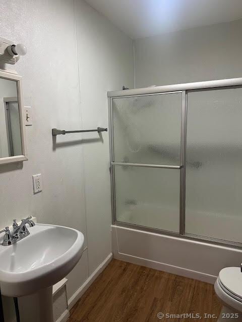 40 Orchard St, Bristol, CT 06010 - full bathroom featuring wood finished floors, bath / shower combo with glass door, toilet, and a sink