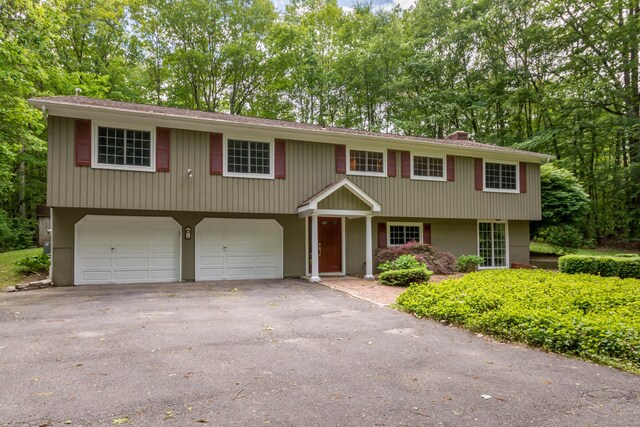 4 Leopard Dr, Newtown, CT 06482 - view of front of home featuring a garage, asphalt driveway, and view of scattered trees