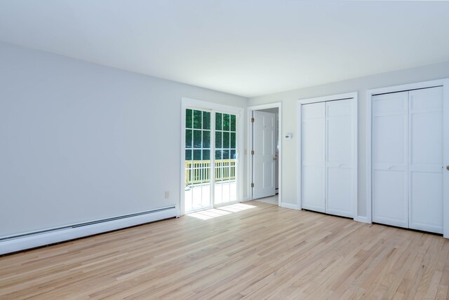 4 Leopard Dr, Newtown, CT 06482 - unfurnished bedroom featuring a baseboard radiator, multiple closets, wood finished floors, and access to outside