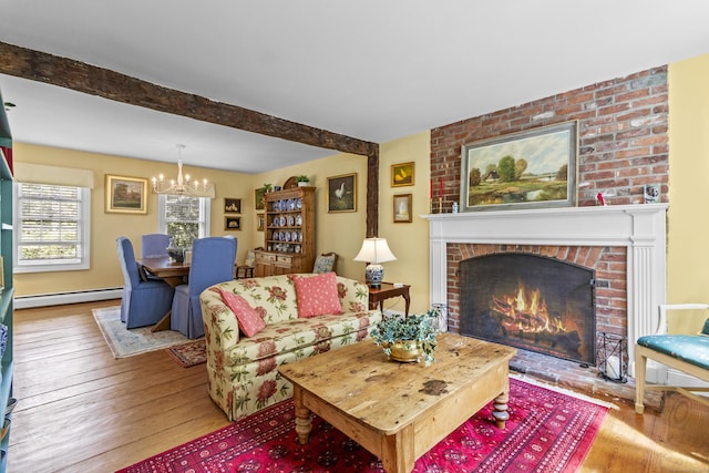 94 Glen Rd, Newtown, CT 06482 - living area featuring a baseboard heating unit, a chandelier, wood-type flooring, a brick fireplace, and beam ceiling