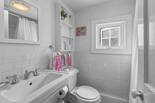 94 Glen Rd, Newtown, CT 06482 - bathroom featuring tile walls, a sink, tiled shower, toilet, and a wainscoted wall