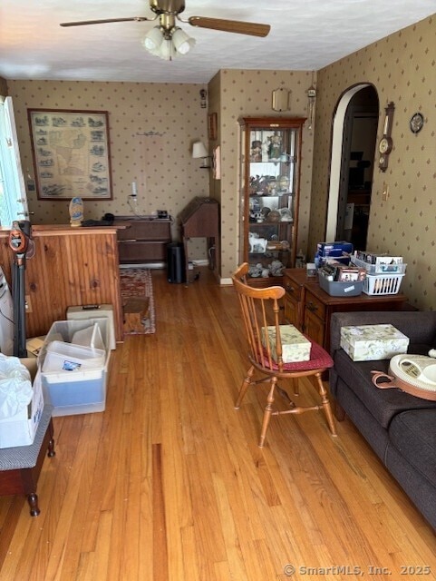78 Pleasant View Rd, Thomaston, CT 06787 - living area featuring wallpapered walls, arched walkways, a ceiling fan, and light wood-type flooring