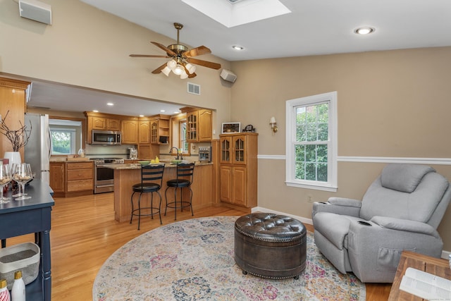 22 Lake Shore Dr, Middlefield, CT 06455 - living room featuring ceiling fan, plenty of natural light, vaulted ceiling, light wood finished floors, and a skylight