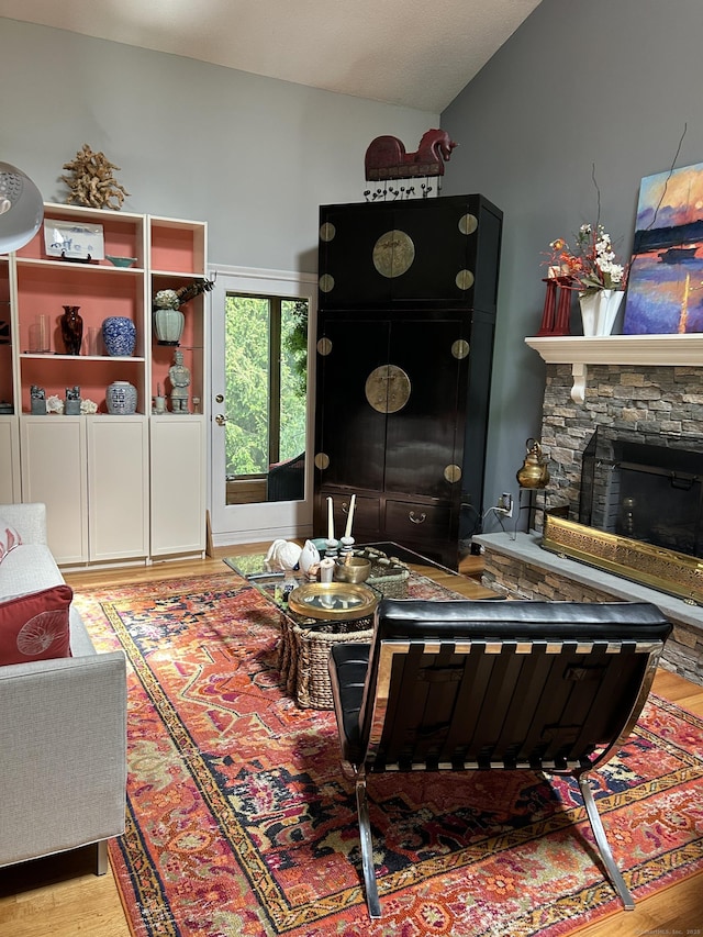 310 Weatherly Trl, Guilford, CT 06437 - living room featuring vaulted ceiling, light wood-style floors, and a stone fireplace