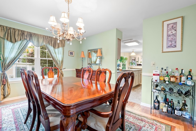 55 Oak Ridge Ln, Milford, CT 06461 - dining space featuring a chandelier, light wood-style floors, and baseboards