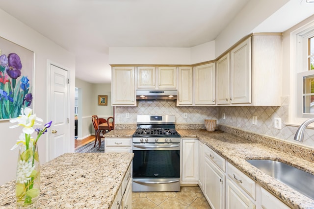 55 Oak Ridge Ln, Milford, CT 06461 - kitchen with stainless steel range with gas stovetop, a sink, under cabinet range hood, and backsplash