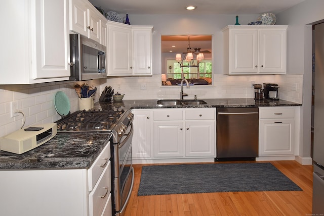 63 Hudson Ln Unit 63, Windsor, CT 06095 - kitchen with appliances with stainless steel finishes, a sink, white cabinets, a chandelier, and light wood-style floors