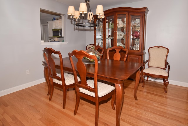 63 Hudson Ln Unit 63, Windsor, CT 06095 - dining area with a chandelier, light wood finished floors, and baseboards