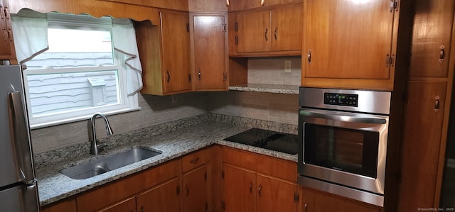 71 Sherry Ln, New Milford, CT 06776 - kitchen with stainless steel appliances, a sink, tasteful backsplash, brown cabinets, and light stone counters