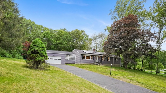 56 Great Neck Rd, Trumbull, CT 06611 - view of front of property featuring an attached garage, solar panels, asphalt driveway, a front lawn, and a chimney