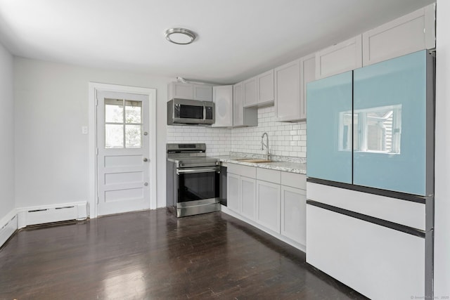 184 Merritt St, Bridgeport, CT 06606 - kitchen with appliances with stainless steel finishes, a sink, baseboard heating, decorative backsplash, and dark wood-type flooring